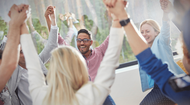 Group of diverse people holding hands with their hands up above their heads. Smiling. Church Equip Curriculum. Building an Outreach to Your Community