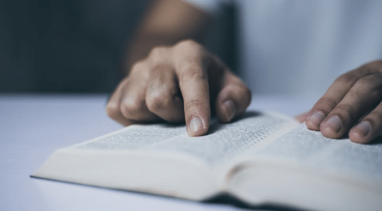 Open Bible with finger pointing on the page